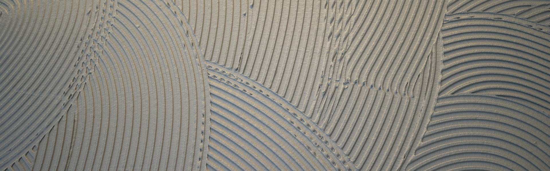 aufgespachtelter grauer Bauklebstoff