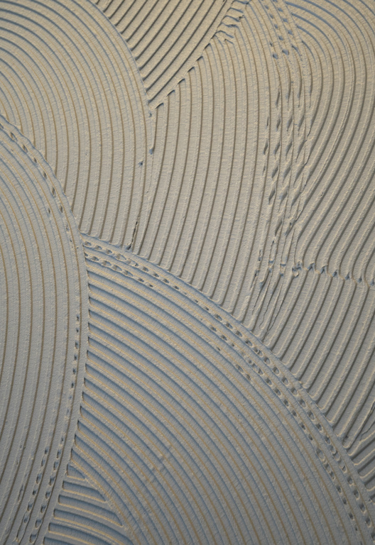 aufgespachtelter grauer Bauklebstoff