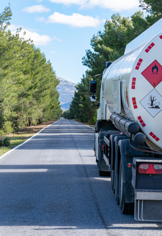 LKW auf Landstraße mit Gefahrgutsymbol
