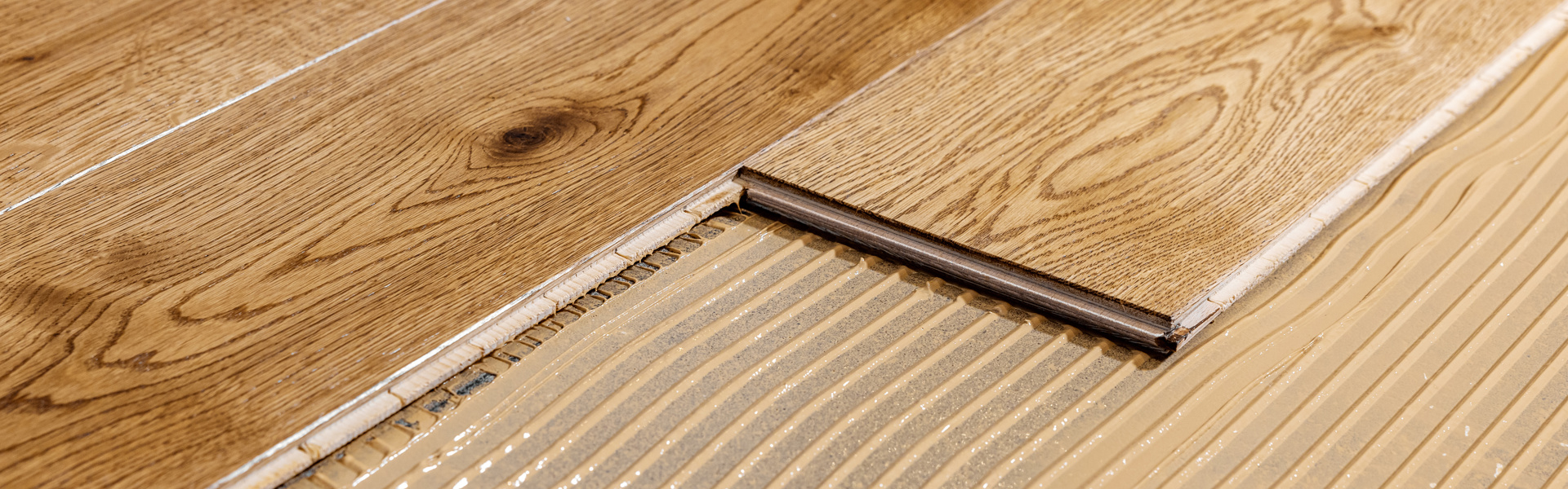 Parkett wird mit Baukleber verlegt